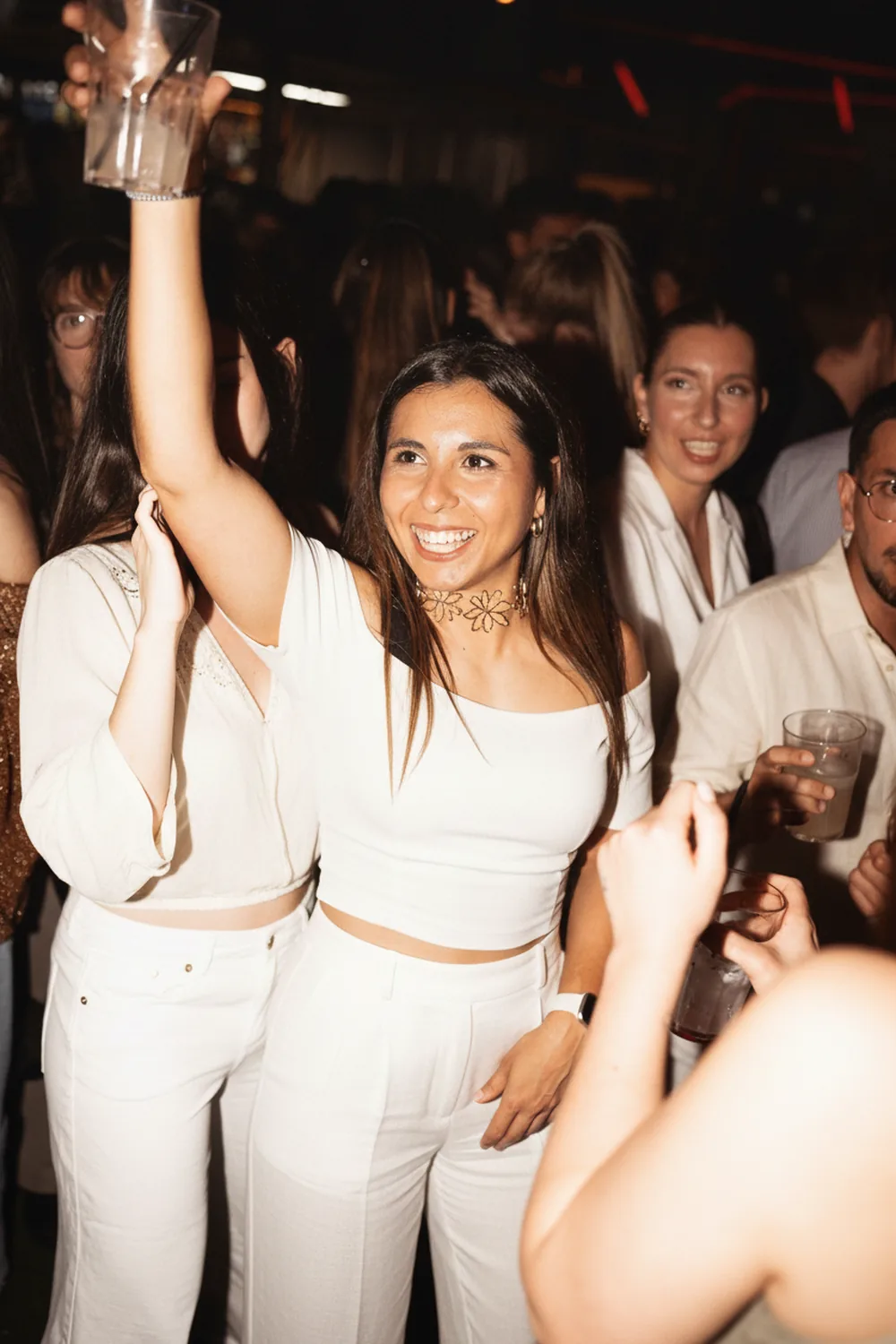 Gente vestida de blanco en la White Party del Racó Mediterrani durante las Hogueras de Alicante, en La Explanada